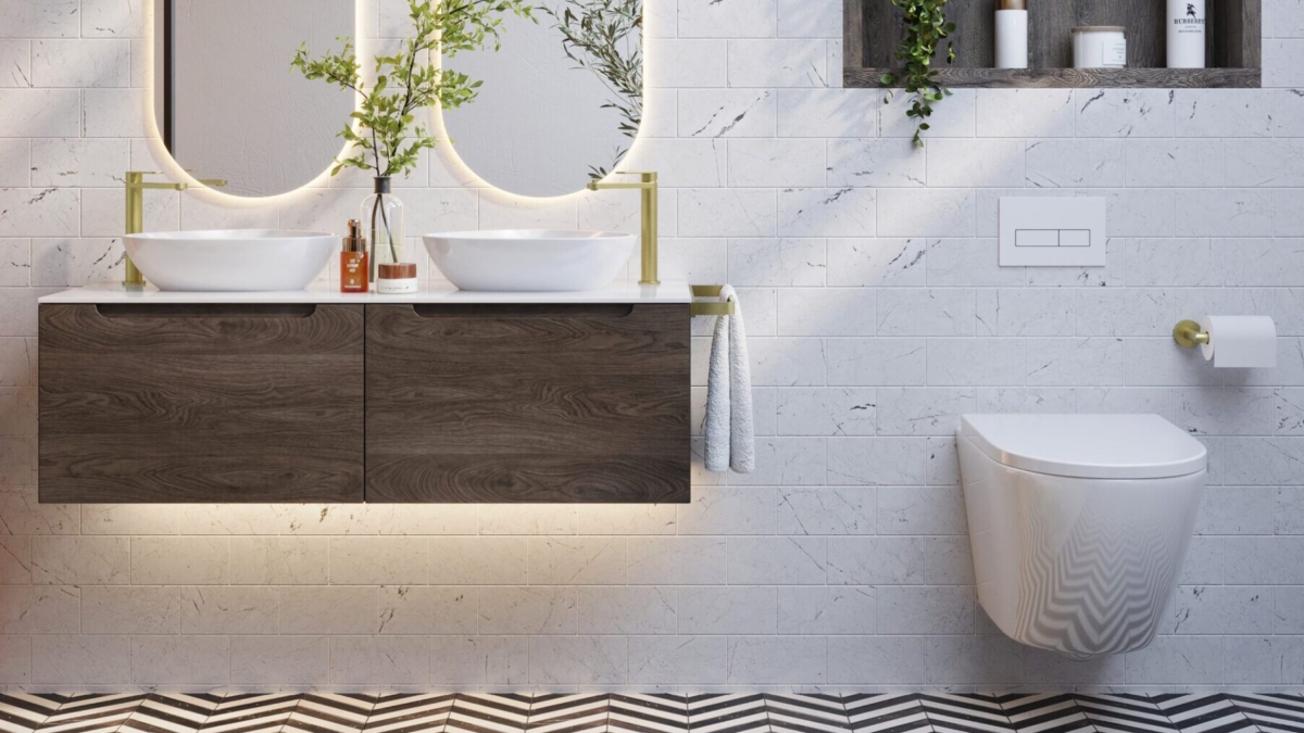 Armera bathroom featuring a floating dark wood vanity unit with double countertop basins, brushed brass fittings, marble effect brick tiles, a monochrome chevron floor, and a wall-hung toilet with recessed shelving.