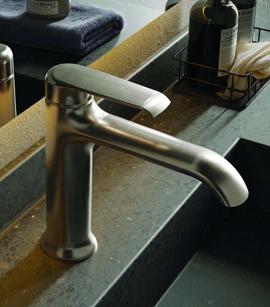 Close-up of the Vaere basin tap in brushed chrome, mounted on a composite dark grey terrazzo basin.